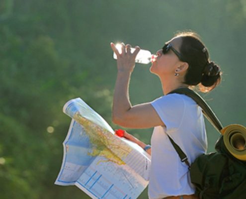 Foto de una mujer bebiendo en su viaje