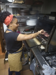 Cocinera de Abrasador Casa Benito cocinando con horno de brasa de carbon ecologico Abrasador 